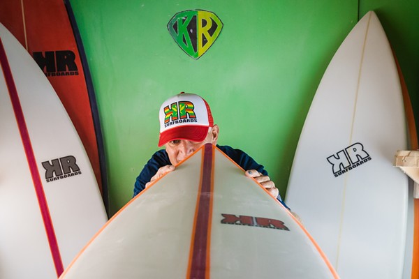 Kurt Roberts, owner and shaper of KR Surfboards, examines the lines of a freshly shaped board in his Los Osos shaping room. - PHOTO BY JAYSON MELLOM