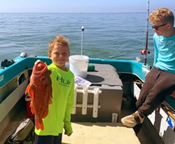 FISHY FISHY Eric Collier, 8, holds up the biggest catch of the day! A red rockfish that he caught himself out on the water near Port San Luis. - PHOTO COURTESY OF WIL COLLIER