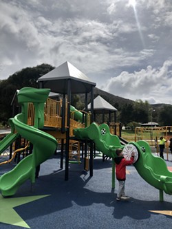 PLACE TO PLAY A young Lompoc resident tinkers with Beattie Park’s new inclusive playground shortly after its unveiling. - PHOTO BY MALEA MARTIN
