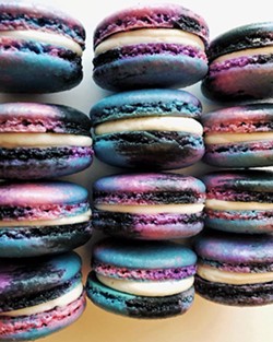 ETHEREAL TREATS Galaxy macarons with coconut buttercream are achieved by coloring separate batches of batter then combining them into a larger piping bag. The resulting hues make each cookie unique. - PHOTO COURTESY OF NIGHT SHIFT COOKIE CO.