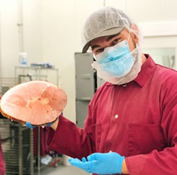 PIG OUT Fourth-year animal science major Avery De Mello (pictured) is one of the 20 students employed by Cal Poly Meats who handle ham production and sales. - PHOTOS COURTESY OF CAL POLY COLLEGE OF AGRICULTURE, FOOD AND ENVIRONMENTAL SCIENCES