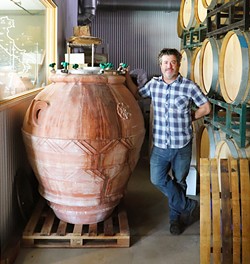 ANCIENT METHODS Christopher Ferrara, proprietor and winemaker with Clesi Wines, poses next to an amphora almost as tall as him. Clesi Wines is one of more than a dozen local wineries that are reviving the ancient amphora winemaking method. - PHOTO COURTESY OF THE AMPHORA PROJECT