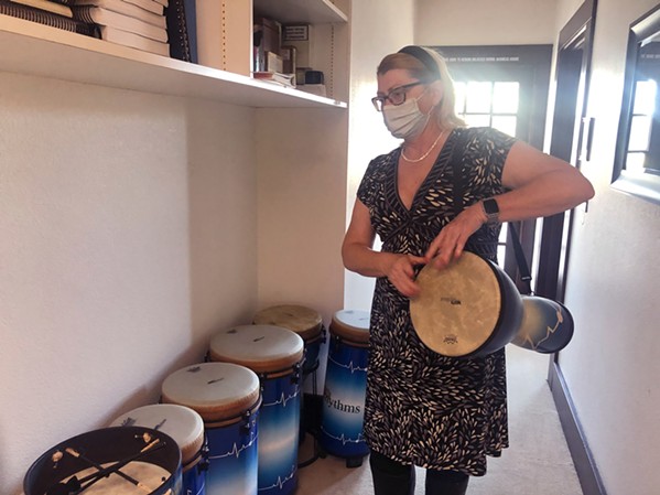 COMMUNITY LEADER Sonya Jackson facilitates drum circles at Hospice SLO with blue Remo hand drums of mixed sizes. - PHOTO BY BULBUL RAJAGOPAL
