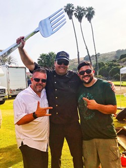 TINEY TROPHY Festival hosts and radio personalities Jeremy West, left, and Adam Montiel, right, congratulate chef Gregg Wangard on his first-place win at the 2018 Macaroni and Cheese Festival in Avila Beach. - PHOTO COURTESY OF ADAM MONTIEL