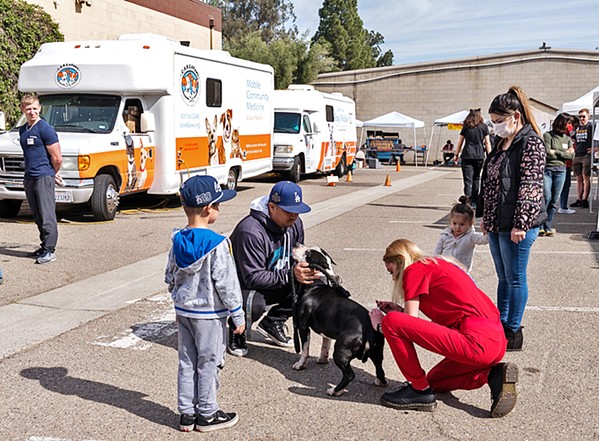 CARING HANDS Volunteers with C.A.R.E.4Paws provide animals in need with vaccines and care&mdash;and the organization is currently fundraising for a larger mobile clinic to bring vets to the animals. - PHOTO COURTESY OF C.A.R.E.4PAWS