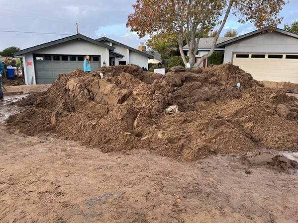 UNSAFE A pile of shoveled mud sits in front of a Los Osos home red-tagged by building officials after the Jan. 9 storm. Dozens of houses countywide are unsafe to inhabit after flooding and mudslides. - PHOTO BY CAMILLIA LANHAM