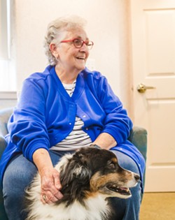FAMILIAR FACES Wyndham Residence's Jean Codorniz pets Alliance of Therapy Dogs-credentialed Moosh, who is a frequent visitor during therapy hours at the assisted living facility. - COVER PHOTO BY JAYSON MELLOM