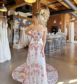 FLORALS AND PATTERNS A wedding dress with a few pops of color brings a nice contrast to the traditional white dress and is something not typically seen on wedding days. - PHOTO COURTESY OF MOONDANCE BRIDAL