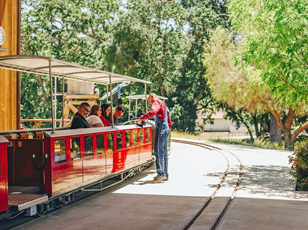 WHET YOUR WHISTLE Halter Ranch chief mechanical officer and conductor Branden Blanke of Paso Robles offers train passengers a complimentary glass of 2023 ros&eacute; prior to embarking on a 3-mile loop of the 2,700-acre Paso estate. - COURTESY PHOTO BY ROBIN OSGOOD