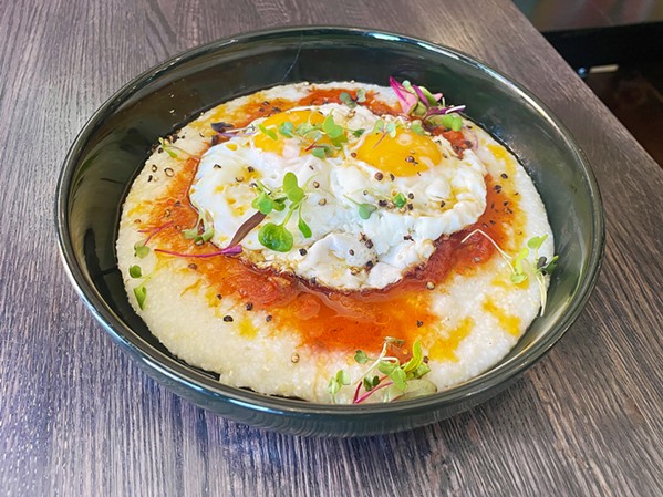 LOWCOUNTRY RIFF I &amp; I's shakshouka, from Tunisia, gets a Southern twist with grits. Fried eggs soak up a savory tomato sauce with olive oil, peppers, onion, and garlic, while grits add texture for a hearty blend of African and American cuisines. - PHOTO BY CHERISH WHYTE