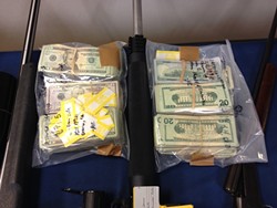 LAWYERS, GUNS, AND MONEY :  An early morning raid on eight residences in the Nipomo area netted more than 60 weapons, about $155,000 in cash, and 12 arrests for alleged drug trafficking activity. - PHOTO COURTESY OF SLO COUNTY SHERIFF&rsquo;S OFFICE