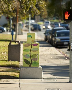 ORNAMENTAL, AS WELL AS USEFUL:  Aaron Landrith, a senior architecture student, discusses the city's role in curating artistic taste through its commissioning of painted utility boxes, such as this one by local artist Marcia Harvey. - PHOTO BY STEVE E. MILLER