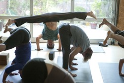 WHERE THE SUN DOES SHINE:  Peter Sterios (pictured, in headstand) leads an early-morning yoga class at his studio, m.Body Yoga & Massage. - PHOTO BY STEVE E. MILLER