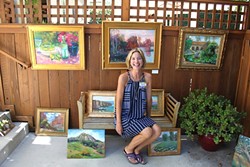 OPEN AIR:  Christine Cortese sits with her oil paintings in the driveway of fellow artist for Art Obispo&rsquo;s Open Studios Art Tour 2015. - PHOTO BY REBECCA LUCAS