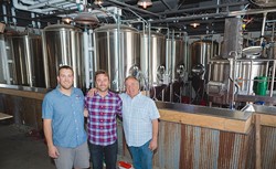 FAMILY TRADITION:  From left, Figueroa Mountain Brewing Co. Arroyo Grande Taproom head brewer David Trailles; founder/owner Jaime Dietenhofer; and his father, brewery owner Jim Dietenhofer, pose for a photo inside their newly constructed taproom opening Father&rsquo;s Day weekend. - PHOTO BY KAORI FUNAHASHI