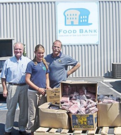 SUSTENANCE :  Volunteer Christine Allen, Food Bank Executive Director Carl Hansen (left), and Food Bank Warehouse Manager Stan Schecter coordinate the distribution of high-protein meals thanks to donations arranged through 4-H. - PHOTO BY DEBBIE ALLEN