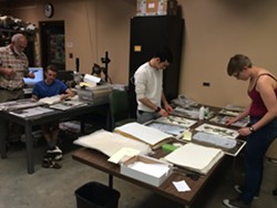 PRESERVE:  Volunteers dry and glue plant samples to archival paper. - PHOTO BY JENN YOST