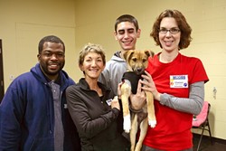 DOG LOVERS:  Woods Humane Society staff members (left to right) Chris Williams (customer service manager), Michelle Rizzi (behavioral trainer and manager), Eric Stockam (animal caregiver), and Chelsea Mills (master trainer and volunteer) are deeply devoted to the animals they care for. - PHOTO BY GLEN STARKEY