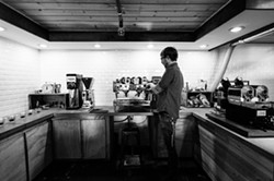 COFFEE CRAFTSMAN:  Part chemist, part coffee guru, Kreuzberg roaster Shawn Clark meticulously roasts batches of specialty beans in the coffee shop&rsquo;s onsite roastery. - PHOTO BY KAORI FUNAHASHI