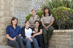 CREDIT DUE :  Friends Kaya and Barbara (seated center) are two of the first &ldquo;generation&rdquo; of AB109 inmates released from SLO County Jail to have found success and sobriety after release. They told New Times that success has everything to do with new programs run by&mdash;and the relationships built with&mdash;local jail officials such as new Jail Programs Manager Alison Ordille (seated left), correctional Deputy Lacie Silviera (back center), and Correctional Cpt. Michele Cole. - PHOTO BY STEVE E. MILLER
