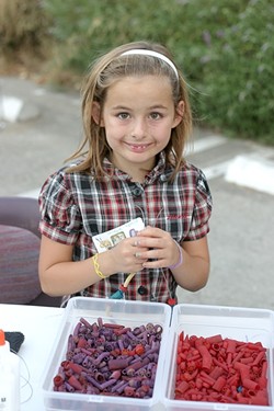 MACARONI NECKLACE QUEEN :  Sevryn Jiminez, 9, crafts a necklace at one of the craft stations set up during the Salon 544 silent auction. - PHOTO BY GLEN STARKEY