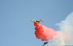 BOMBS AWAY :  A CDF bomber dropped a payload of fire retardant - compound on a field of wildfire fuel on June 23. - PHOTO BY JESSE ACOSTA