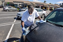 SPRAY ON, WIPE OFF:  Lamar Harrison from Clean and Green Auto Care &ldquo;washes&rdquo; a car in the Smart & Final parking lot off Grande Avenue in Arroyo Grande without using any water. - PHOTO BY CAMILLIA LANHAM