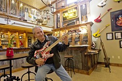 SIPS AND RIFFS:  Gary Kramer sits at his wine tasting room in Paso Robles where rare guitars owned by rock &rsquo;n&rsquo; roll legends like Gene Simmons and Eddie Van Halen hang. - PHOTO BY JAYSON MELLOM