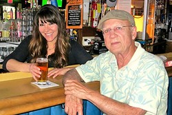LOCAL HOT SPOT:  Local author Tod Rafferty (right) with Shannon Geyer at Harry&rsquo;s Bar in Pismo Beach, one of the settings for his novel The Pismo Calamity. - PHOTO COURTESY OF TOD RAFFERTY