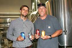 WE CAN DO IT:  From left, SLO Brew Director of Marketing Brian Kerr and Brewmaster Steve Courier showcase their new 23-ounce cans. - PHOTO BY HAYLEY THOMAS