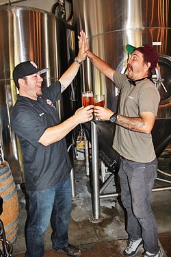 BEER FIVE:  Central Coast Brewing Co. Head Brewer Brendan Gough (left) and Libertine Brewing Co. Co-Owner/Brewmaster Tyler Clark go for a &ldquo;high-five/beer-five.&rdquo; - PHOTO BY HAYLEY THOMAS