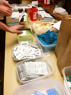 HARM REDUCTION Volunteers at the SLO Bangers Syringe Exchange prepare clean needles and other supplies to give away to drug users in order to help prevent the spread of wounds and diseases. - PHOTO COURTESY OF LOIS PETTY
