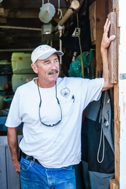 HOIST MASTER Dockworker Howie Kennett helps unload fishing vessels and operates an icehouse on Olde Port pier. - PHOTO BY JAYSON MELLOM