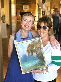 A CYCLE OF GOOD Paula DeLay (left), curator for The Monday Club pop-up and a featured artist, poses with the buyer of DeLay's donation piece. One-hundred percent of the sale will benefit the annual Fine Arts Awards. - PHOTO COURTESY OF SHELLEY GIBSON