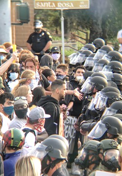 TENSE Protesters stand face-to-face with law enforcement officers outside of the SLO Police Department on the afternoon of June 1. - PHOTO BY PETER JOHNSON