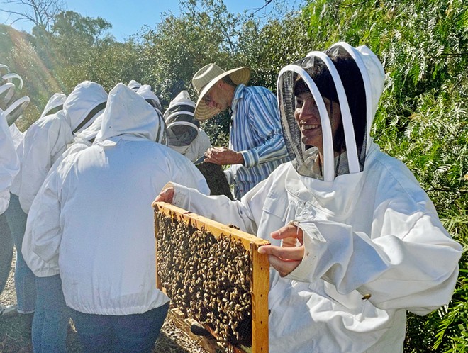 BEE WHISPERER California Bee Company owner Jeremy Rose (center, in striped shirt) dons a hat but no protective suit while teaching at Cal Poly. He is slated to speak at Paso Robles' Golden Oak Honey and Pumpkin Festival on Oct. 23.