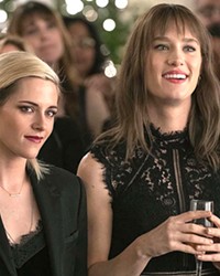 HOMECOMING OUT When Abby (Kristen Stewart, left) agrees to join her girlfriend, Harper (Mackenzie Davis), at her family's home for the holidays, she soon discovers Harper has been harboring a secret that threatens their otherwise solid relationship, in Happiest Season, screening on Hulu.