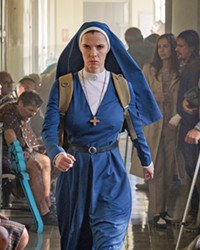 JESUS' WIFE Betty Gilpin stars as Sister Simone, a nun fighting an artificial intelligence, in the deeply weird sci-fi dramedy Mrs. Davis, streaming on Peacock.