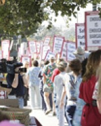 LINE OF SIGNS :  On July 26, members of the California Nurses Association and other supporters marched with signs and shouted slogans to call awareness to ongoing negotiations with Catholic Healthcare West.