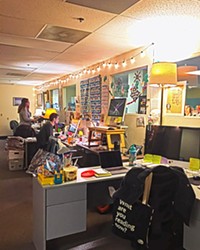 COZY This editorial duo has ditched the traditional fluorescent lighting and lit up the office with lamps and string lights.